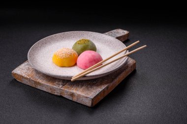 Lezzetli Asya mochi tatlısı pirinç hamuru kabuğu ve koyu beton arka planda meyveler.