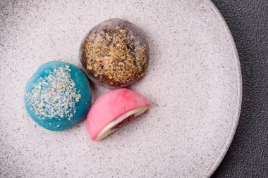 Lezzetli Asya mochi tatlısı pirinç hamuru kabuğu ve koyu beton arka planda meyveler.