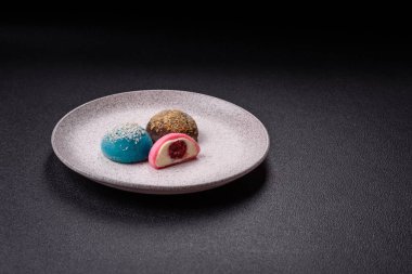 Lezzetli Asya mochi tatlısı pirinç hamuru kabuğu ve koyu beton arka planda meyveler.