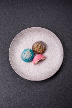 Lezzetli Asya mochi tatlısı pirinç hamuru kabuğu ve koyu beton arka planda meyveler.