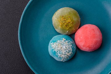 Lezzetli Asya mochi tatlısı pirinç hamuru kabuğu ve koyu beton arka planda meyveler.