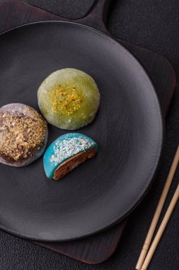 Lezzetli Asya mochi tatlısı pirinç hamuru kabuğu ve koyu beton arka planda meyveler.