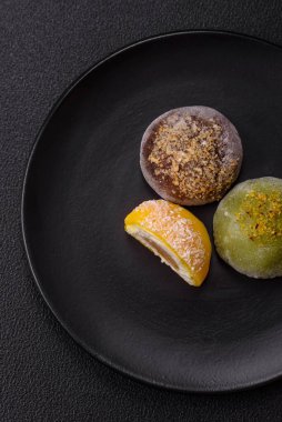 Lezzetli Asya mochi tatlısı pirinç hamuru kabuğu ve koyu beton arka planda meyveler.