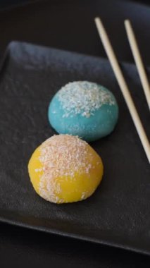 Lezzetli Asya mochi tatlısı pirinç hamuru kabuğu ve koyu beton arka planda meyveler.