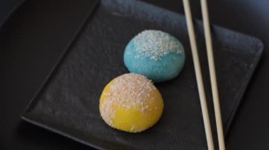 Lezzetli Asya mochi tatlısı pirinç hamuru kabuğu ve koyu beton arka planda meyveler.