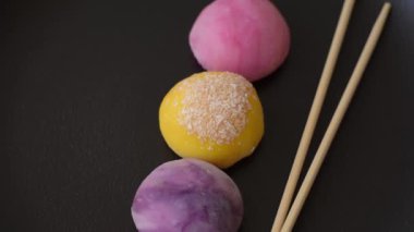 Lezzetli Asya mochi tatlısı pirinç hamuru kabuğu ve koyu beton arka planda meyveler.