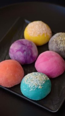 Lezzetli Asya mochi tatlısı pirinç hamuru kabuğu ve koyu beton arka planda meyveler.