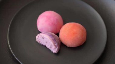 Lezzetli Asya mochi tatlısı pirinç hamuru kabuğu ve koyu beton arka planda meyveler.