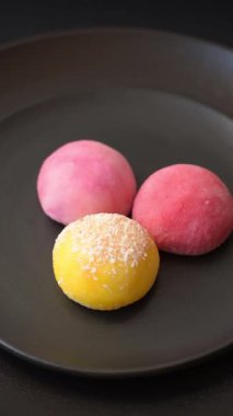 Lezzetli Asya mochi tatlısı pirinç hamuru kabuğu ve koyu beton arka planda meyveler.