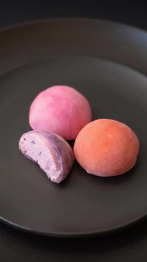 Lezzetli Asya mochi tatlısı pirinç hamuru kabuğu ve koyu beton arka planda meyveler.