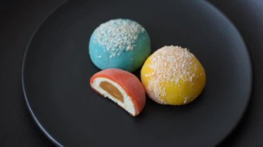 Lezzetli Asya mochi tatlısı pirinç hamuru kabuğu ve koyu beton arka planda meyveler.