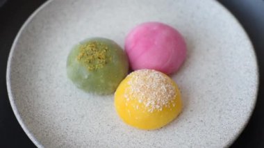Lezzetli Asya mochi tatlısı pirinç hamuru kabuğu ve koyu beton arka planda meyveler.