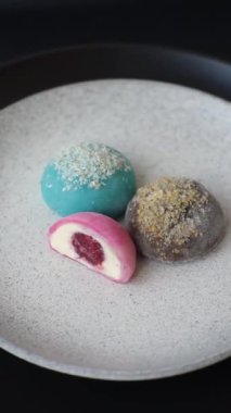 Lezzetli Asya mochi tatlısı pirinç hamuru kabuğu ve koyu beton arka planda meyveler.