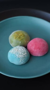 Lezzetli Asya mochi tatlısı pirinç hamuru kabuğu ve koyu beton arka planda meyveler.