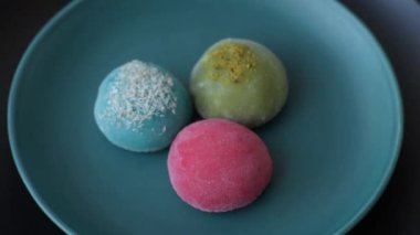 Lezzetli Asya mochi tatlısı pirinç hamuru kabuğu ve koyu beton arka planda meyveler.