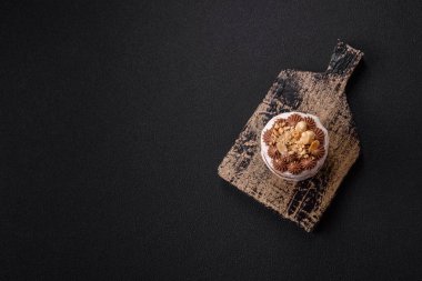 Koyu beton arka planda kremalı, fındıklı tatlı puf tart.