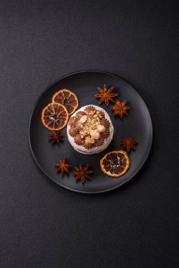 Koyu beton arka planda kremalı, fındıklı tatlı puf tart.