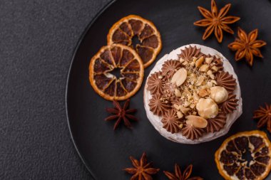 Koyu beton arka planda kremalı, fındıklı tatlı puf tart.