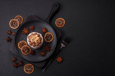 Koyu beton arka planda kremalı, fındıklı tatlı puf tart.