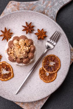 Koyu beton arka planda kremalı, fındıklı tatlı puf tart.