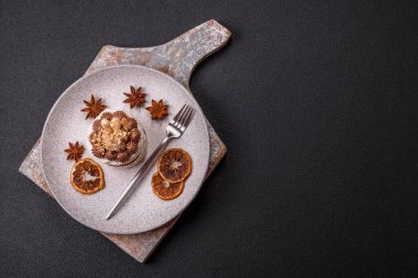 Koyu beton arka planda kremalı, fındıklı tatlı puf tart.