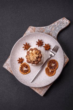 Koyu beton arka planda kremalı, fındıklı tatlı puf tart.