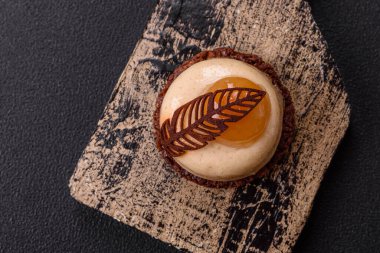 Armut limonlu kremalı tatlı tart ve koyu beton arka planda çikolatalı kek tabanı.