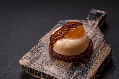 Armut limonlu kremalı tatlı tart ve koyu beton arka planda çikolatalı kek tabanı.