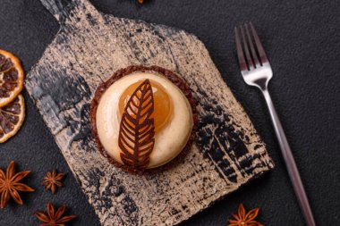 Armut limonlu kremalı tatlı tart ve koyu beton arka planda çikolatalı kek tabanı.