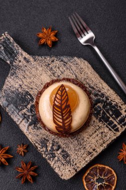 Armut limonlu kremalı tatlı tart ve koyu beton arka planda çikolatalı kek tabanı.