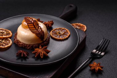 Armut limonlu kremalı tatlı tart ve koyu beton arka planda çikolatalı kek tabanı.