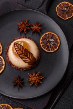 Armut limonlu kremalı tatlı tart ve koyu beton arka planda çikolatalı kek tabanı.