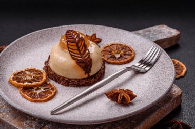 Armut limonlu kremalı tatlı tart ve koyu beton arka planda çikolatalı kek tabanı.