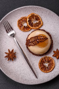 Armut limonlu kremalı tatlı tart ve koyu beton arka planda çikolatalı kek tabanı.