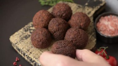 Nohut, baharat ve ottan yapılmış koyu beton arka planda Falafel vejetaryen ve vejetaryen yemekleri