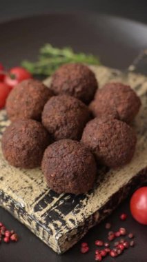 Nohut, baharat ve ottan yapılmış koyu beton arka planda Falafel vejetaryen ve vejetaryen yemekleri