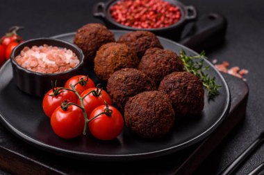 Nohut, baharat ve ottan yapılmış koyu beton arka planda Falafel vejetaryen ve vejetaryen yemekleri