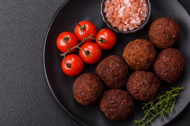 Nohut, baharat ve ottan yapılmış koyu beton arka planda Falafel vejetaryen ve vejetaryen yemekleri