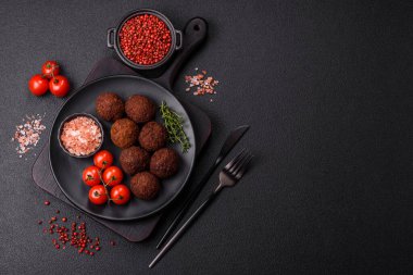 Nohut, baharat ve ottan yapılmış koyu beton arka planda Falafel vejetaryen ve vejetaryen yemekleri