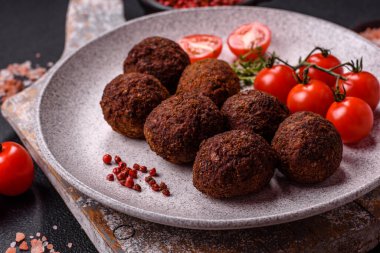 Nohut, baharat ve ottan yapılmış koyu beton arka planda Falafel vejetaryen ve vejetaryen yemekleri