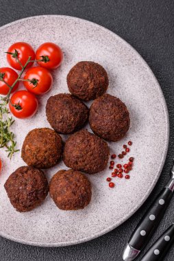 Nohut, baharat ve ottan yapılmış koyu beton arka planda Falafel vejetaryen ve vejetaryen yemekleri