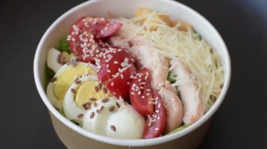 Marullu taze salata, kızarmış ekmek, tavuk filetosu, domatesler ve koyu beton arka planda yumurta.