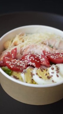 Marullu taze salata, kızarmış ekmek, tavuk filetosu, domatesler ve koyu beton arka planda yumurta.