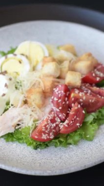 Marullu taze salata, kızarmış ekmek, tavuk filetosu, domatesler ve koyu beton arka planda yumurta.