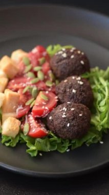 Lezzetli kızarmış falafel nohuttan, kimyondan, tuzlu humus ve baharatlı koyu beton arka planda.