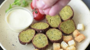 Lezzetli kızarmış falafel nohuttan, kimyondan, tuzlu humus ve baharatlı koyu beton arka planda.