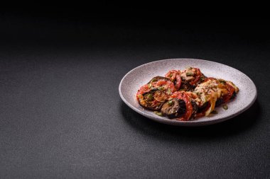 Patlıcan, domates ve kabak halkaları. Sos içinde tuz ve baharatla pişirilmiş tavuk ve sarımsak parçaları.