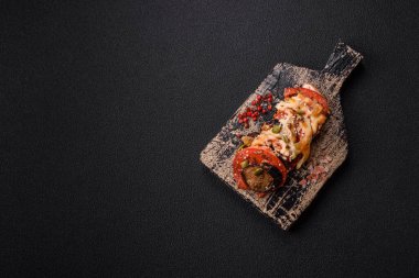 Patlıcan, domates ve kabak halkaları. Sos içinde tuz ve baharatla pişirilmiş tavuk ve sarımsak parçaları.