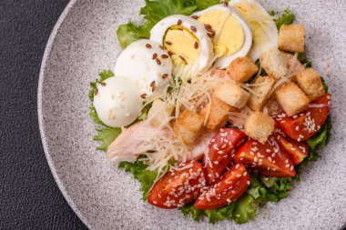 Marullu taze salata, kızarmış ekmek, tavuk filetosu, domatesler ve koyu beton arka planda yumurta.