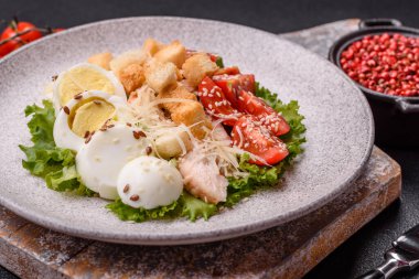 Marullu taze salata, kızarmış ekmek, tavuk filetosu, domatesler ve koyu beton arka planda yumurta.